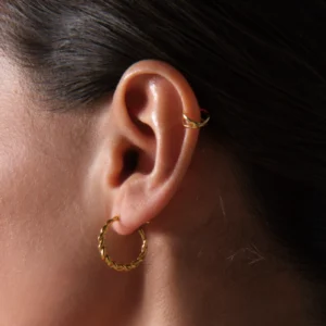 kolczyk koło skręcony z nausznicą skrzyzowane koła w zbliżeniu na uchu modelki