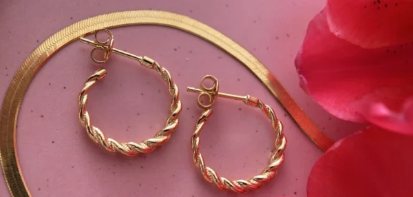 kolczyki i zmijka kwiat kolczyki koła i naszyjnik żmijka obok kwiat