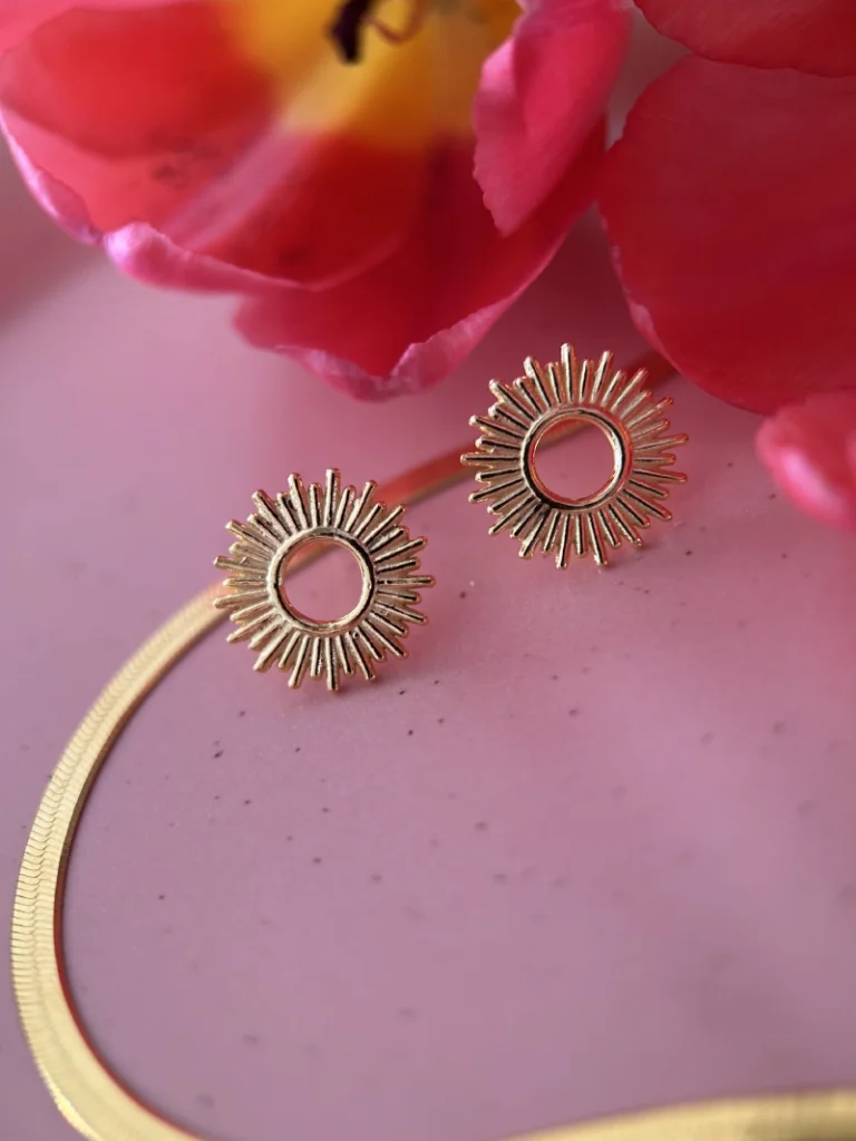 kolczyki słoneczka i żmijka na podkładzie obok tulipana