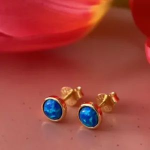 Kolczyki z niebieskim opalem przy kwiatach