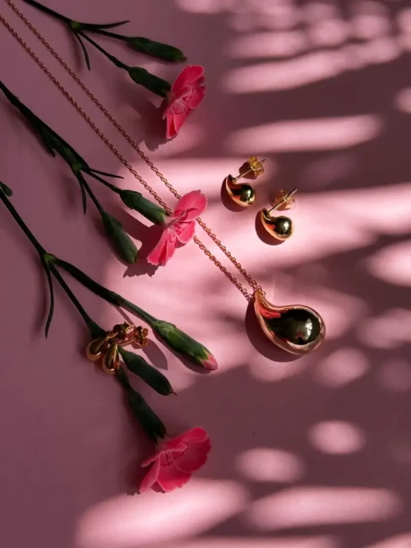 naszyjnik kropla w stylizacji naszyjnik kropla w stylizacji z kolczykami na tle kwiatów