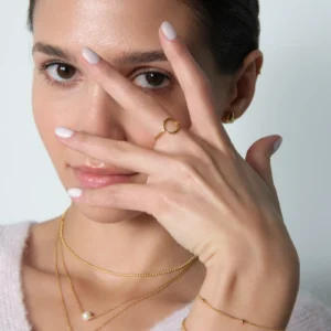 modelka prezentująca set naszyjników i pierścionek z kółeczkiem