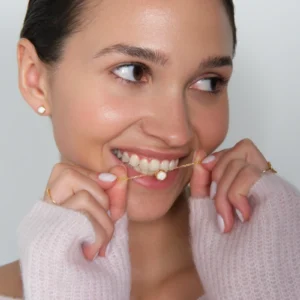 modelka prezentuje w zębach naszyjnik z opalem pozłacany i kolczyki z opalem