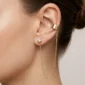pozłacany kolczyk z nausznicą i łańcuszkiem stylizacja ucha na modelce
